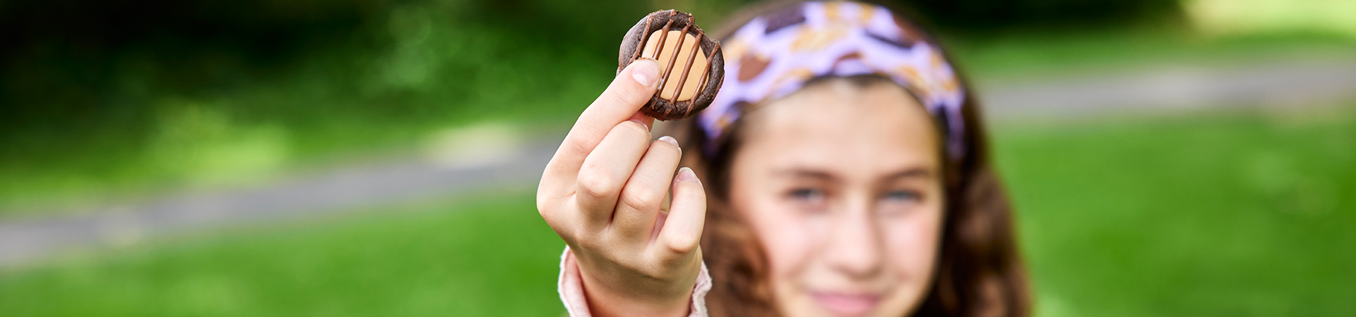  girl scout wearing uniform sash putting trefoil girl scout cookie boxes into cookie transport bag 